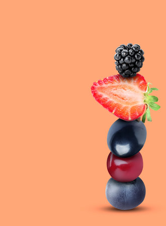Stack of different fresh tasty berries on light coral background, space for textの写真素材