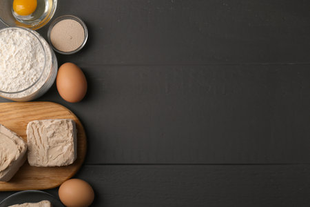 Different types of yeast, eggs and flour on gray wooden table, flat lay. Space for textの写真素材