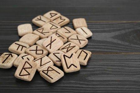 Pile of runes on black wooden tableの写真素材