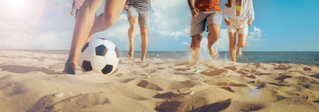Friends playing football on beach during sunny day, closeup. Banner designの写真素材