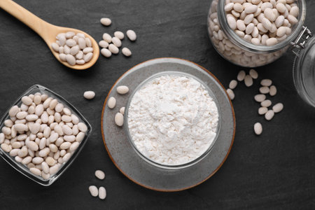 Bean flour and seeds on black table, flat layの写真素材