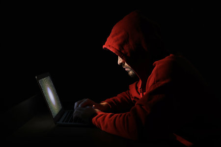 Hacker working with laptop in dark room. Cyber attack