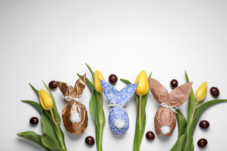 Flat lay composition with Easter bunnies made of paper and eggs on white background. Space for textの写真素材
