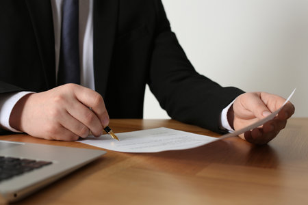 Notary signing document on wooden table, closeupの写真素材