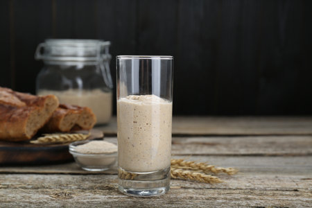 Glass with fresh sourdough on wooden tableの写真素材
