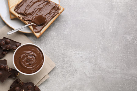 Tasty breakfast. Flat lay composition with sweet paste and chocolate pieces served on gray textured table. Space for textの写真素材