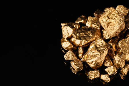 Pile of shiny gold nuggets on black background. Space for textの写真素材