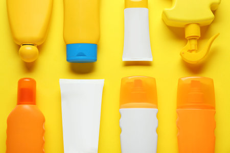 Suntan products on yellow background, flat layの写真素材