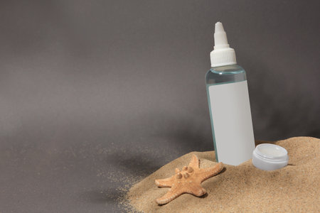 Cosmetic products and starfish on sand against gray background. Space for textの写真素材