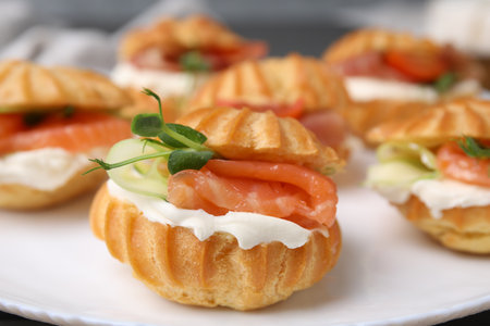 Delicious profiteroles with cream cheese and salmon on plate, closeupの写真素材