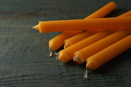 Many church wax candles on old wooden table, closeup. Space for textの写真素材
