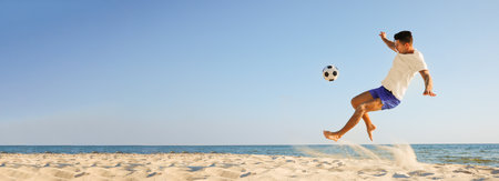 Man playing football on sandy beach, space for text. Banner designの写真素材