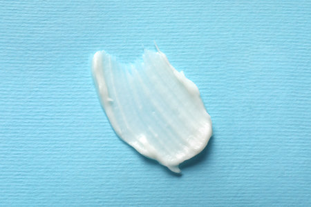 Smear of ointment on light blue background, top viewの写真素材