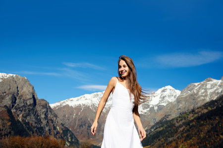 Young woman walking in beautiful mountains on sunny dayの写真素材