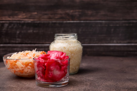 Delicious sauerkraut prepared according to different recipes on brown table, space for textの写真素材