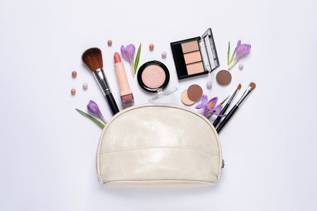 Flat lay composition with different makeup products and beautiful flowers on white backgroundの写真素材