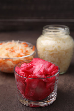 Delicious sauerkraut prepared according to different recipes on brown table, closeupの写真素材