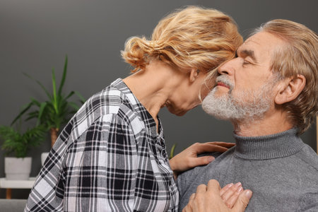 Happy mature couple spending time together on sofa at home. Dating agencyの写真素材