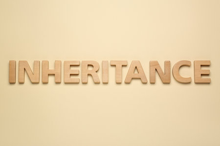 Word Inheritance made with wooden letters on beige background, flat layの写真素材