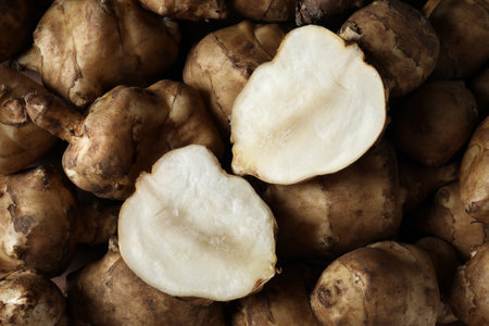 Whole and cut Jerusalem artichokes as background, top viewの写真素材