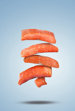Cut fresh salmon falling on pale light blue gradient background