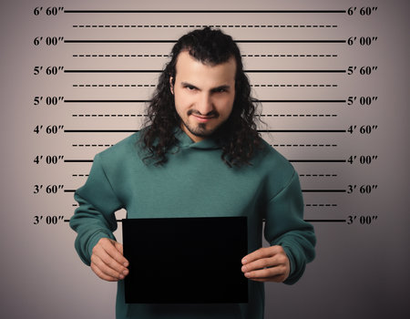 Criminal mugshot. Arrested man with blank card against height chartの写真素材