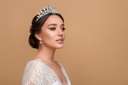 Beautiful young woman wearing luxurious tiara on beige background, space for textの写真素材