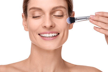 Woman with makeup brush on white backgroundの写真素材