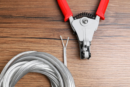 Cutters and cable with stripped wire on wooden table, flat layの写真素材