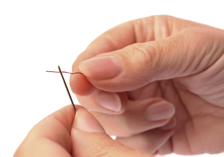 Woman threading sewing needle on white background, closeupの写真素材