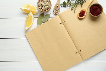 Blank recipe book and different ingredients on white wooden table, flat lay. Space for textの写真素材