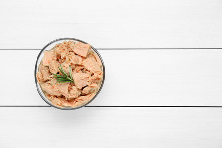 Bowl with canned tuna and rosemary on white wooden table, top view. Space for textの写真素材