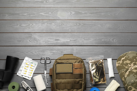 Military first aid kit on wooden table, flat lay. Space for textの写真素材