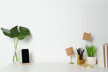 Comfortable workplace with white desk near wall. Space for textの写真素材