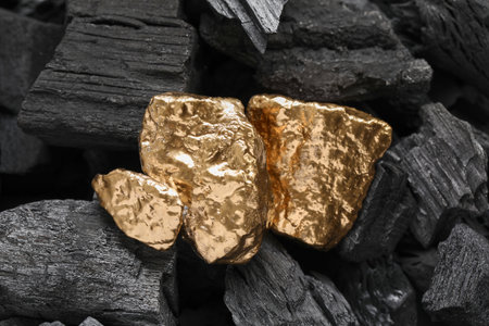 Shiny gold nuggets on coals, closeup viewの写真素材