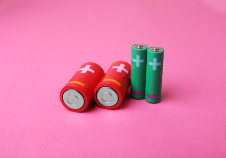New AA and C sizes batteries on pink backgroundの写真素材