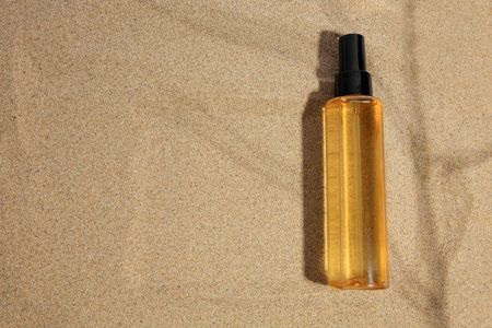 Bottle with serum on sand, top view and space for text. Cosmetic productの写真素材