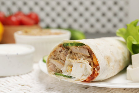Delicious tortilla wrap with tuna on white wicker mat, closeup. Space for textの写真素材