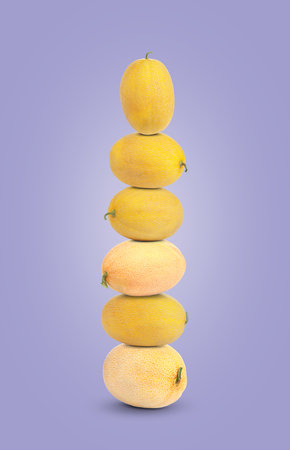 Stack of fresh melons on pastel violet backgroundの写真素材