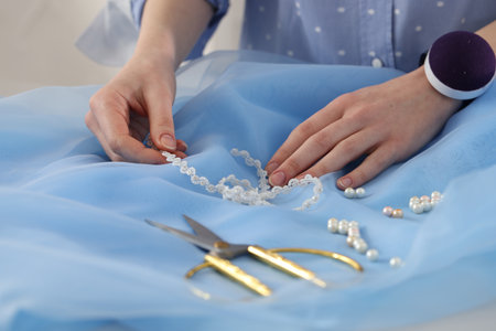 Dressmaker creating new dress in atelier, closeup