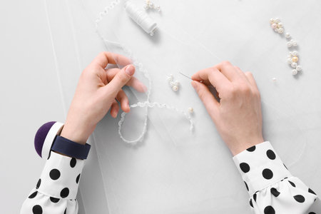 Dressmaker with sewing accessories at white table, top view