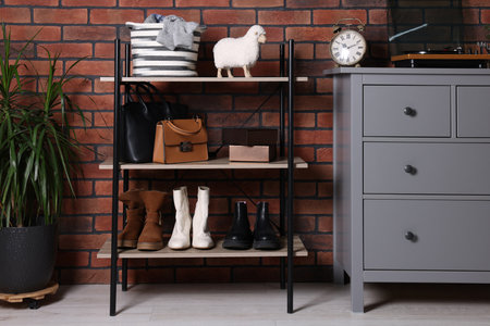 Beautiful hallway interior with chest of drawers and shoe storage bench near red brick wallの写真素材
