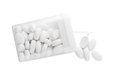 Tasty mint dragee candies with box on white background, top view
