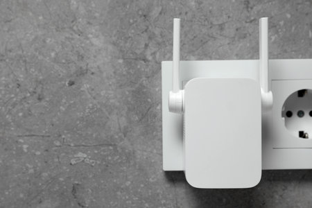 Wireless Wi-Fi repeater on light gray wall, space for textの写真素材