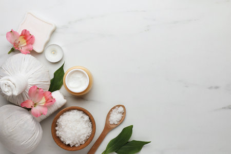 Flat lay composition with spa products and flowers on white marble table. Space for textの写真素材