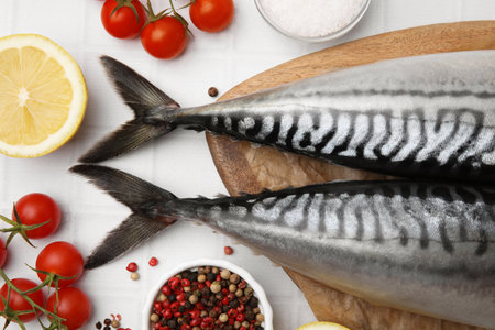 Raw mackerel, tomatoes and lemon on white table, flat layの写真素材