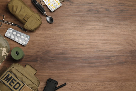 Military first aid kit on wooden table, flat lay. Space for textの写真素材