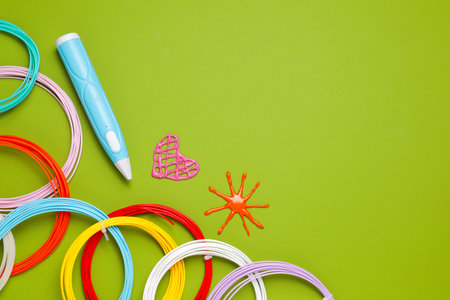 Stylish 3D pen, colorful plastic filaments and different figures on light green background, flat...