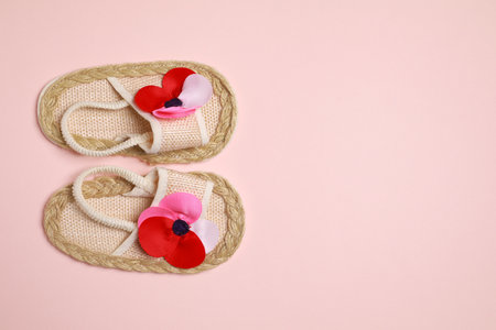 Cute baby shoes on beige background, flat lay. Space for textの写真素材