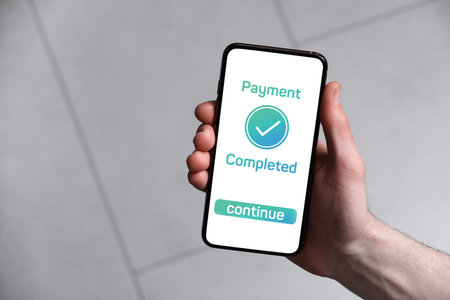 Man successfully made payment using online banking application on smartphone indoors, closeupの写真素材